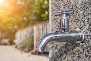 modern metal outdoor faucet with clean drinking water in park on the street in city in summer on a sunny day close-up