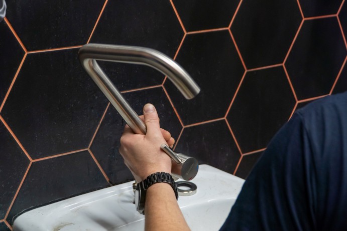 Plumber installing a new bathroom faucet fixture